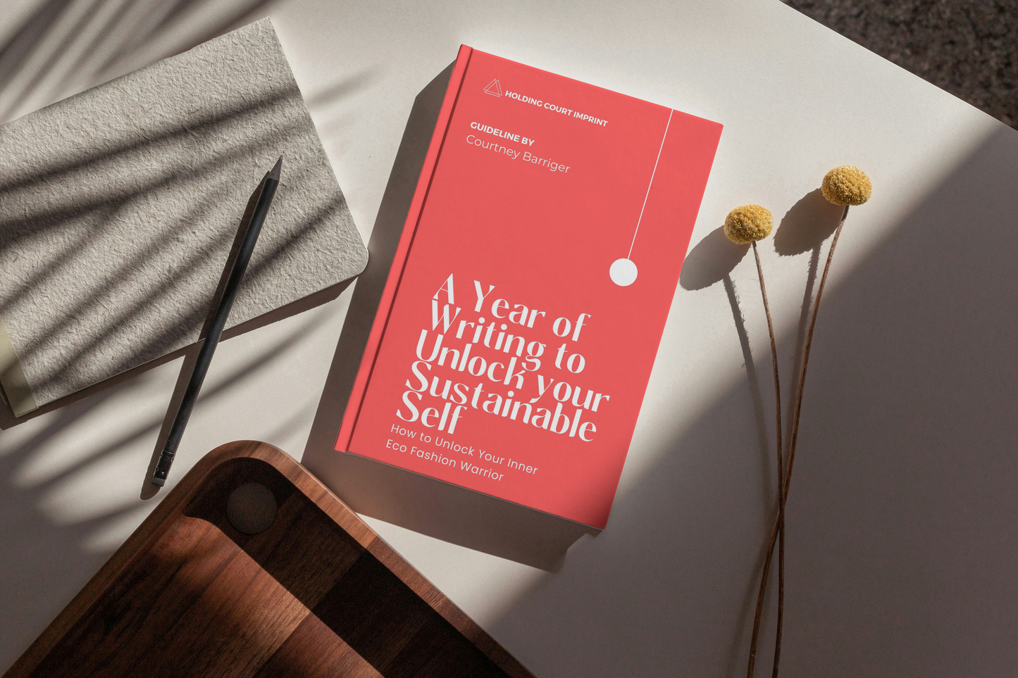 'A Year of Writing to Unlock your Sustainable Self' journal by Courtney Barriger on a desk, ideal for eco-friendly fashion journaling and upcycling tips.