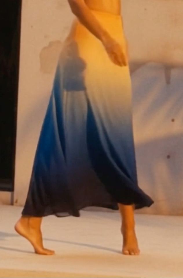 Woman standing in front of a building with a gradient dress