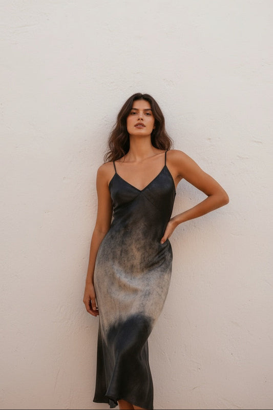 Woman wearing a black and gray gradient slip dress against a white background