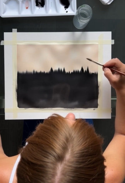 Person painting a black silhouette of trees on white paper with a brush. #Griffin1LunarLanding #MoonArt #SustainableFashion #ArtistsForImpact #BitBasel #LunarArtGallery #ReFiTulum #SpaceArt #EcoFashion #MadeToOrder #OrganicCotton #RecycledFabrics #AuroraBorealis #CosmicFashion #RegenerativeFashion #TheRoyalRobe #CourtneyBarriger #HoldingCourtInc #AstroGLPH #MoonMission2026 #EthicalFashion #SlowFashion #ConsciousClothing #EcoLuxury #SustainableStyle #WatercolorArt #CelestialFashion #FromEarthToMoon #ArtInSpa