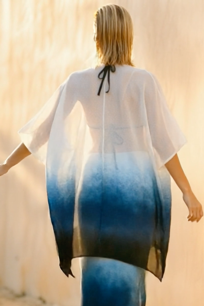 Woman wearing a white and blue gradient dress with a blurred background
