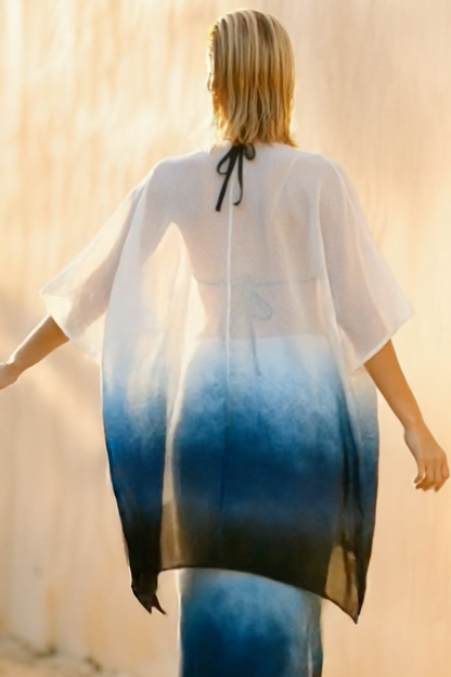Woman wearing a white and blue gradient dress with a blurred background