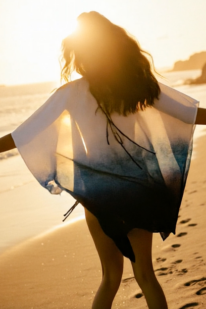 Person standing on a beach with a towel draped over their shoulders, sunlit background