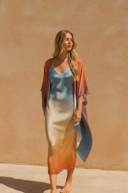 Woman wearing a colorful dress with a gradient effect against a beige wall.