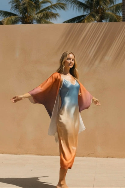 Woman in a colorful dress standing against a beige wall with palm trees in the background
