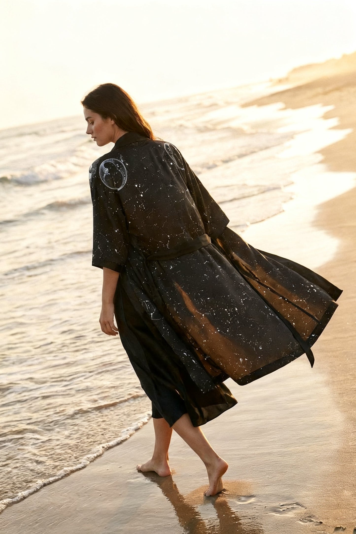 Woman in a black dress walking on a beach