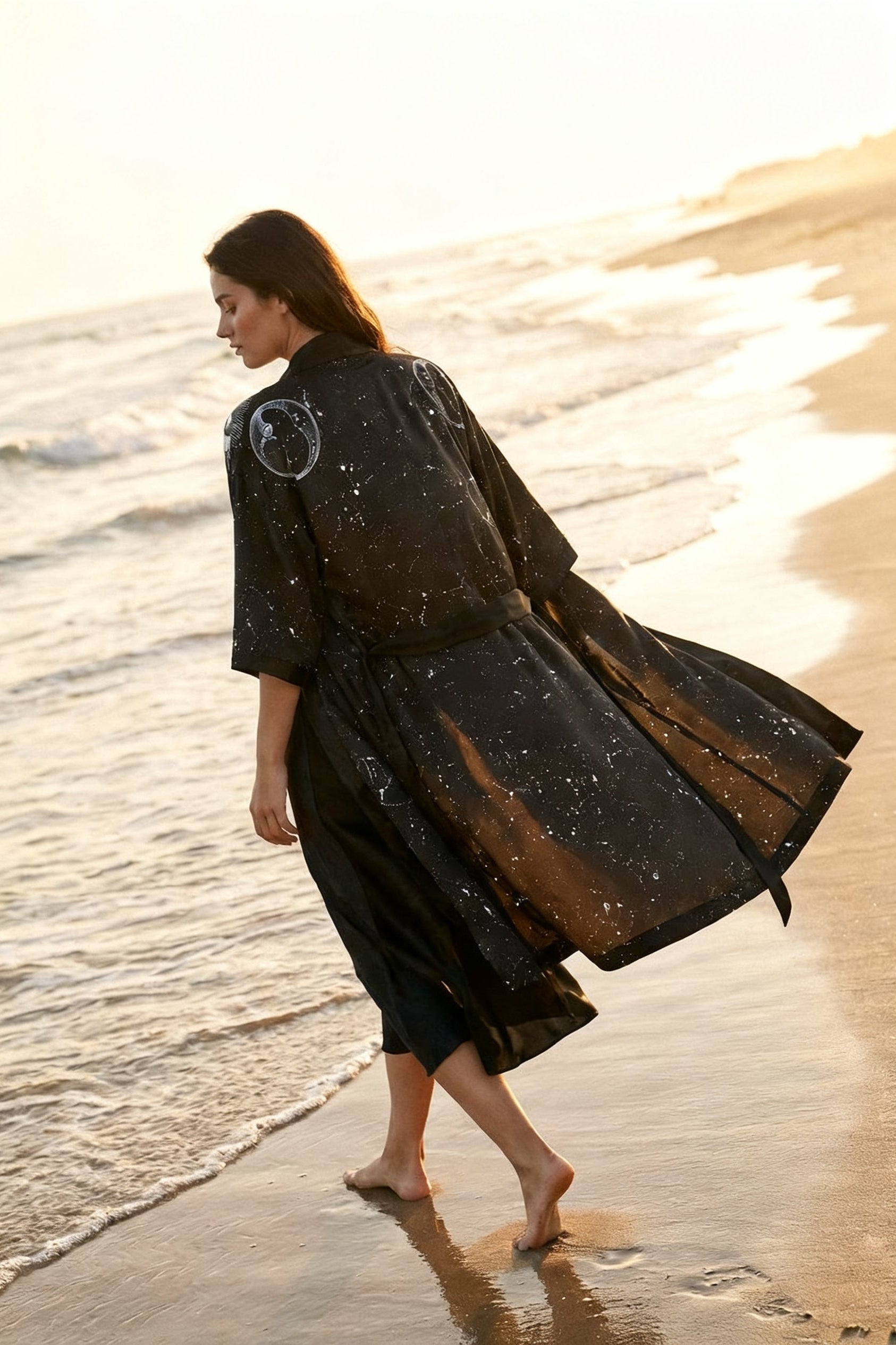 Woman in a black dress walking on a beach