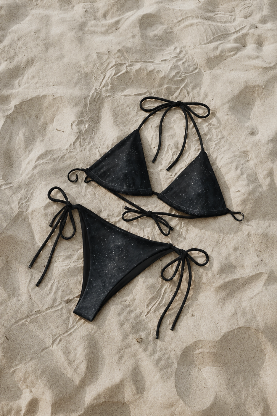 Black triangle bikini set on a textured beige surface