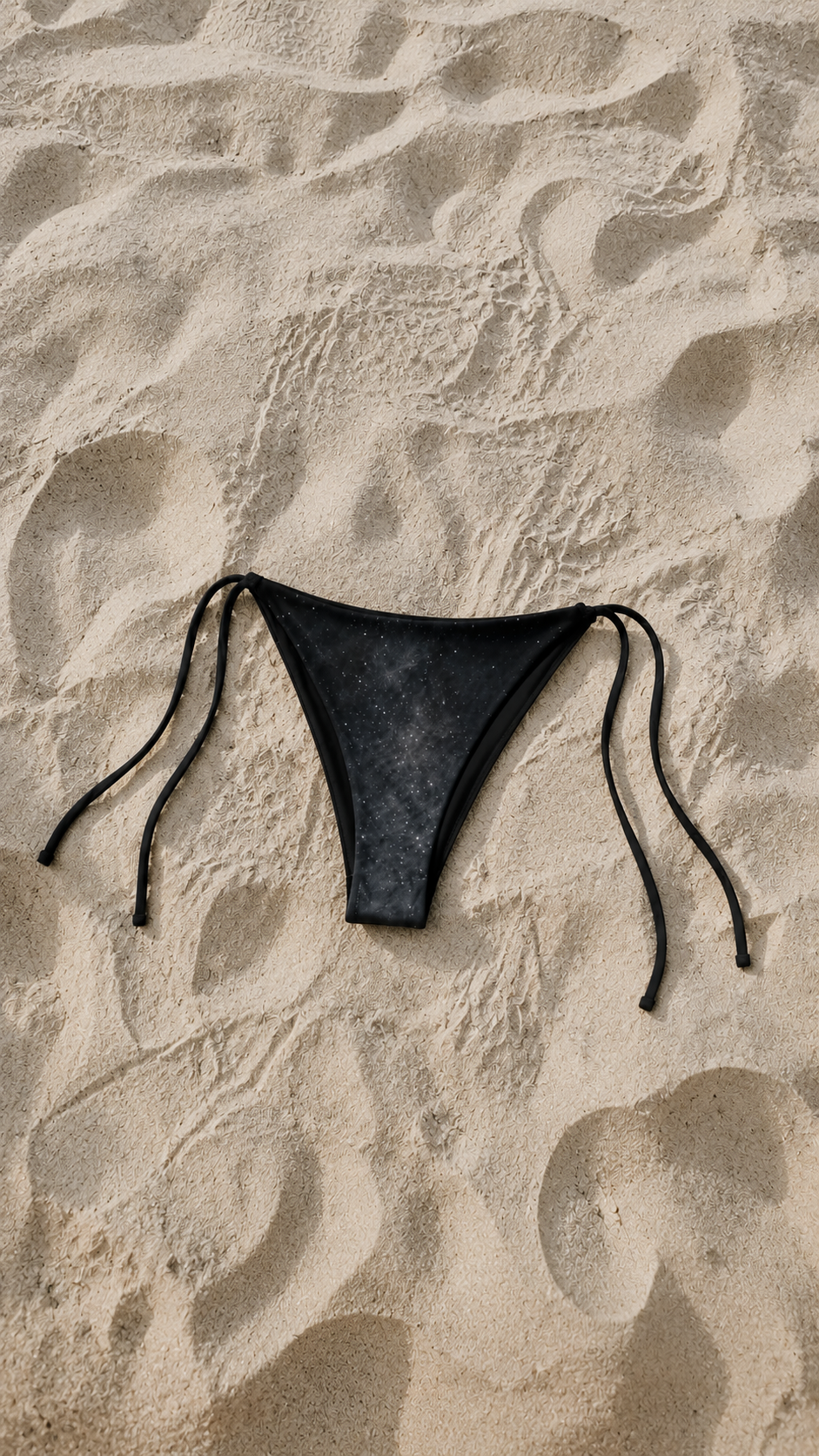 Black bikini bottom on sand