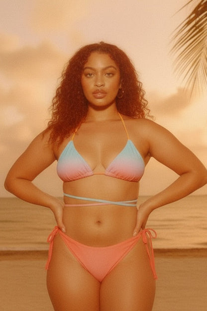 Woman in a colorful bikini standing on a beach with a sunset background